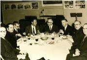 Marcel Bourdages assis à une table d'un restaurant en compagnie de Rodolphe Lavoie et d'hommes non identifiés