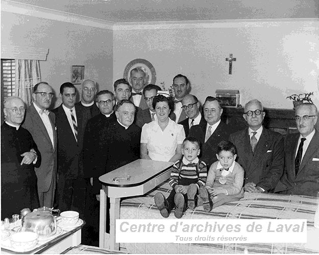 Photographie de groupe dans une chambre  deux lits.