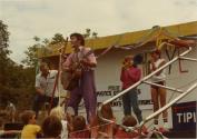 Rallye familial de vélo au Centre de la Nature. Cinq clowns sur scène jouant de la musique devant un jeune public. (Août 1984)