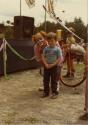 Rallye familial de vélo au Centre de la Nature. Un clown derrière un enfant. (Août 1984)