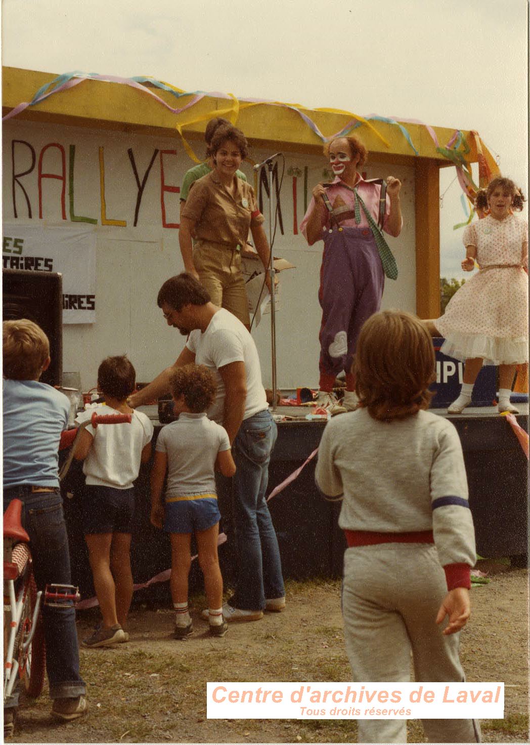 Rallye familial de vlo au Centre de la Nature. Quatre personnes d'animation, dont un clown, sur scne. (Aot 1984)