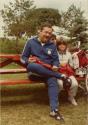 Rallye familial de vélo au Centre de la Nature. Un homme et un enfant sur un banc de parc. (Août 1984)