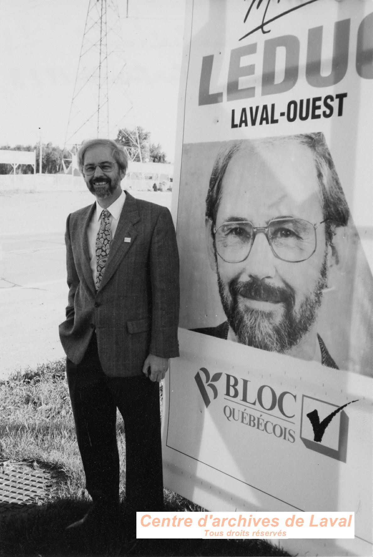 Michel Leduc pose devant son affiche lectorale en 1993