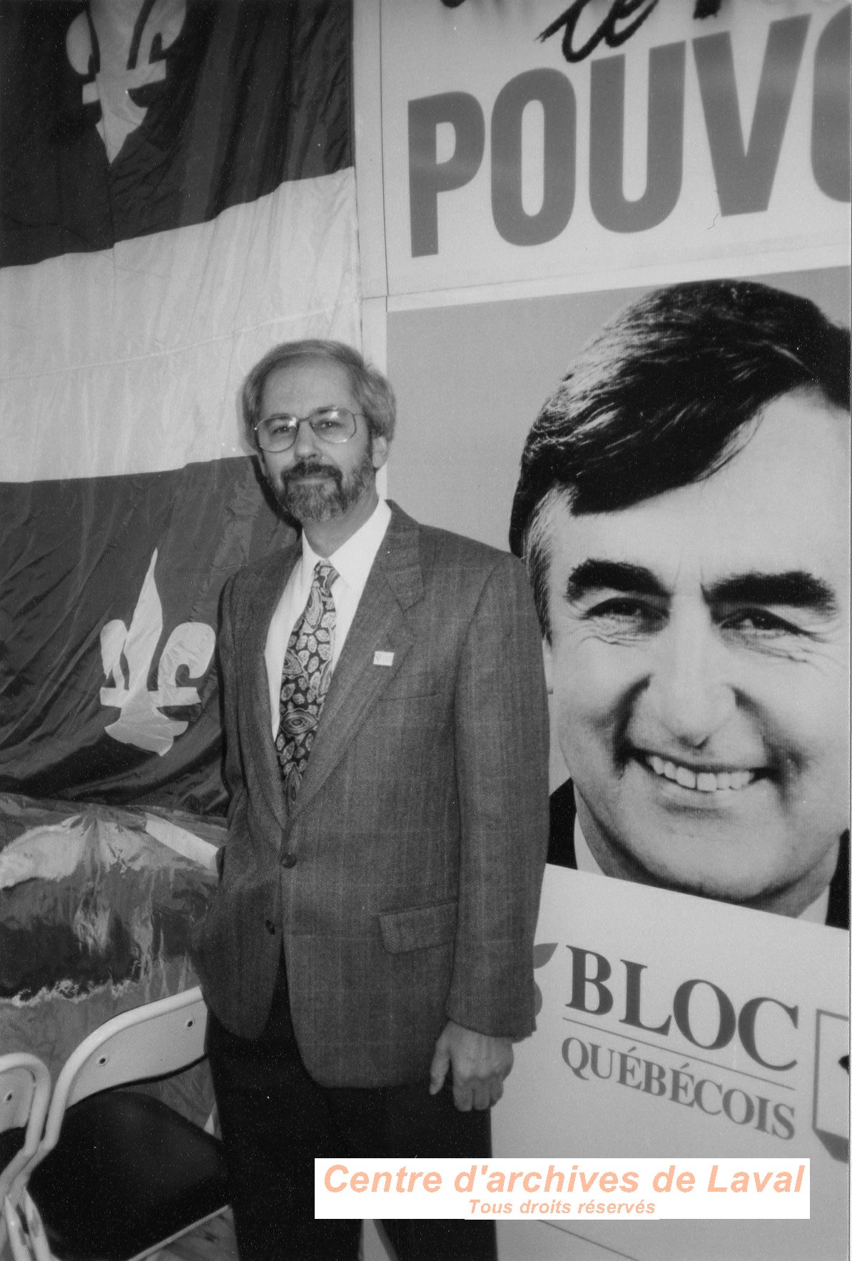 Michel Leduc pose devant une affiche lectorale de Lucien Bouchard lors de la campagne lectorale de 1993