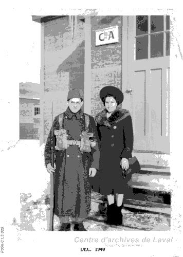 Couple posant devant une caserne militaire.