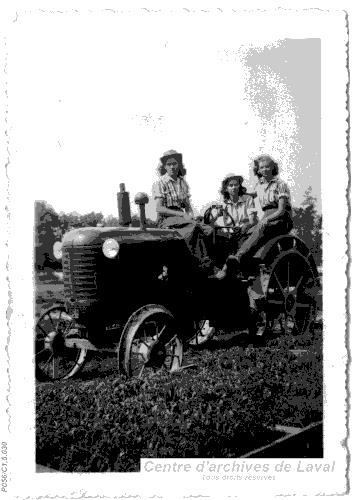 Trois femmes sur un tracteur.