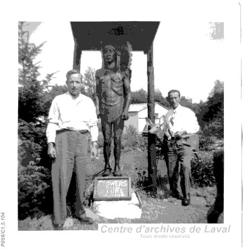 Franois Legault devant une statue reprsentant un autochtone.