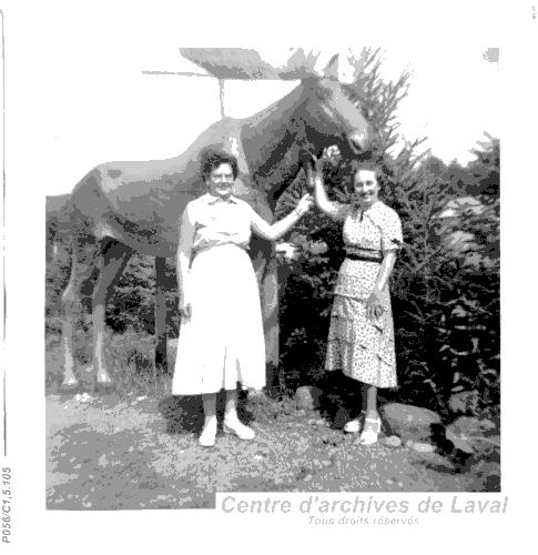 Deux femmes posant avec une statue reprsentant un orignal.