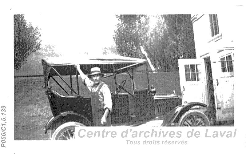 Un homme pose prs d'une voiture.