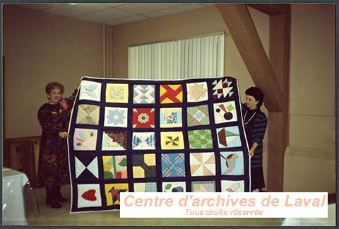 Deux dames, membres du Cercle de fermires de Sainte-Rose/Auteuil exhibent une courtepointe qu'elles ont fabrique