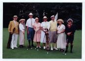 Huit personnes non identifiées posent avec leurs bâtons de golf