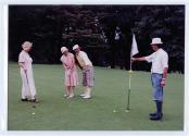 Quatre personnes non identifiées jouent au golf