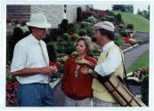 Trois personnes discutent devant le terrain de golf