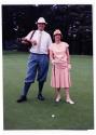 Deux personnes non identifiées posent avec leurs bâtons et une balle de golf
