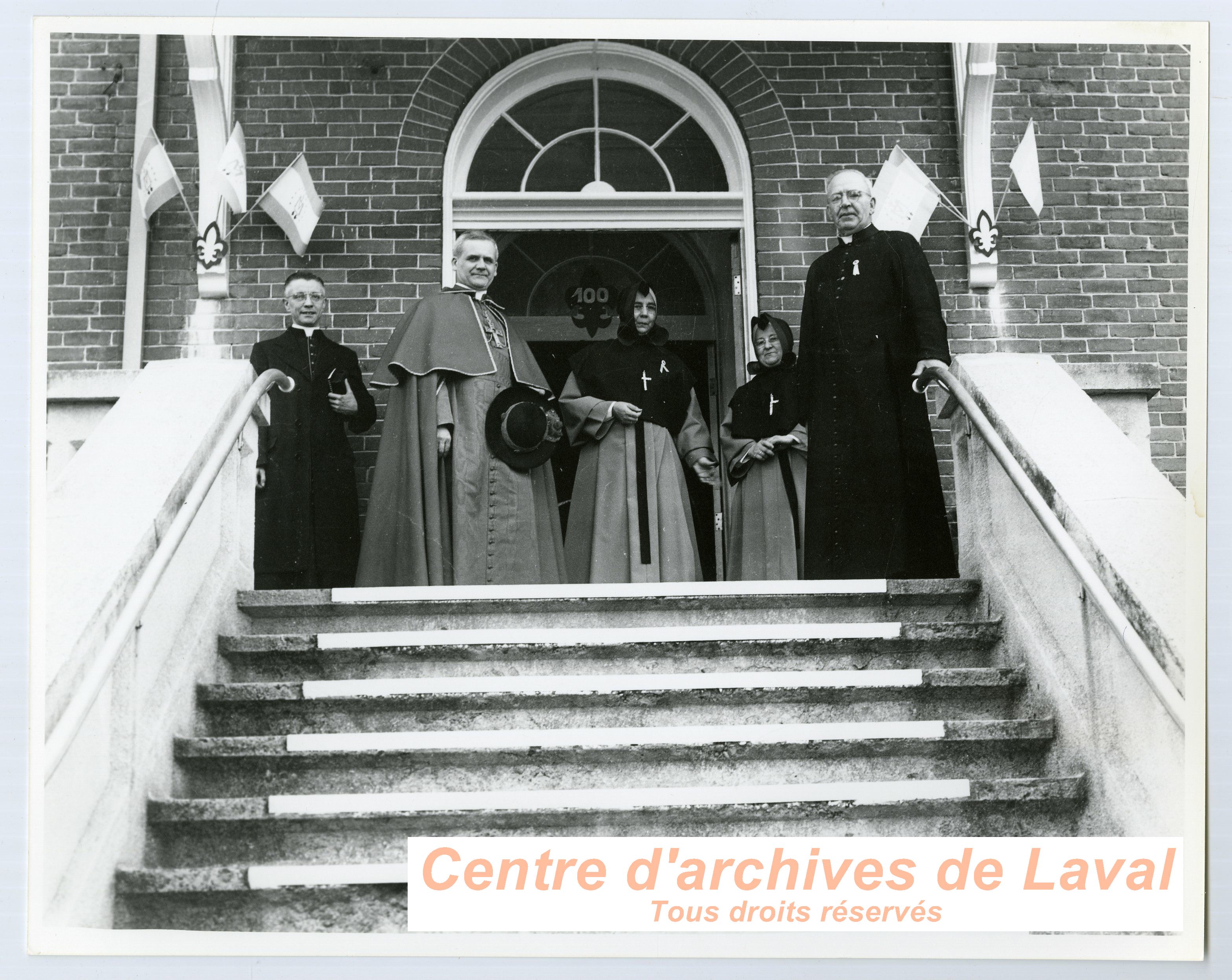 Le cardinal Paul-mile Lger, au milieu, en compagnie du cur Ernest Vaillancourt,  droite, du monseigneur Emilien Frenette,  gauche, et de religieuses lors des clbrations du 100e anniversaire du couvent d'Youville (1854-1954)  Saint-Benot en 1954.