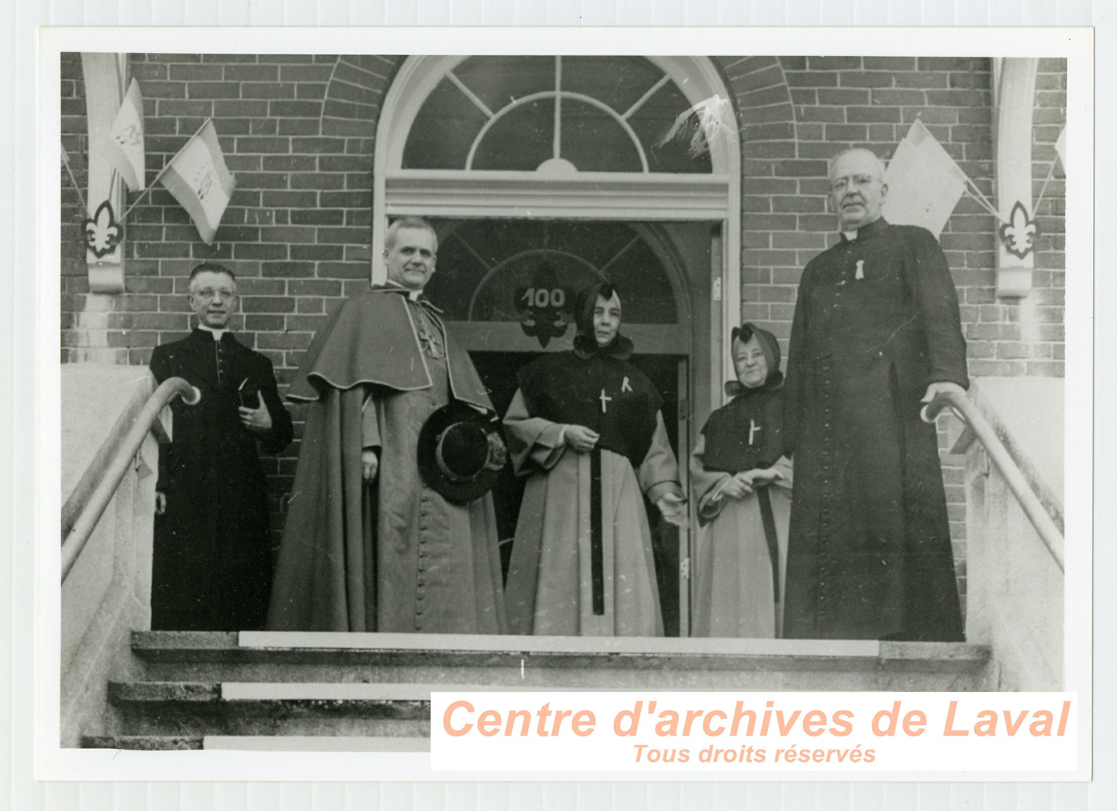 Le cardinal Paul-mile Lger en compagnie du cur Ernest Vaillancourt et de religieuses  lors des clbrations du 100e anniversaire du couvent d'Youville (1854-1954)  Saint-Benot en 1954.