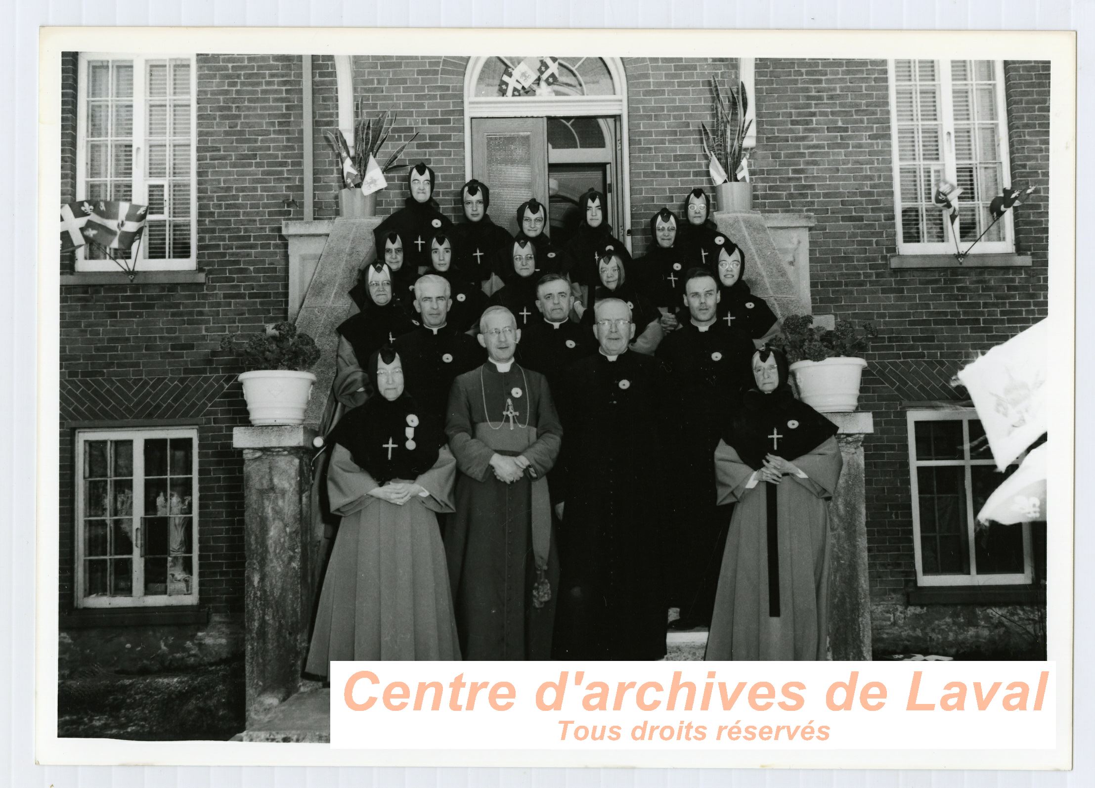 Le cur Ernest Vaillancourt ( l'avant droite) et le monseigneur Emilien Frenette ( l'avant gauche) en compagnie de religieux lors des clbrations du 100e anniversaire du couvent d'Youville (1854-1954)  Saint-Benot en 1954.