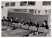 Groupe d'adultes assis  des pupitres  l'cole Girouard de Saint-Benot en 1968.