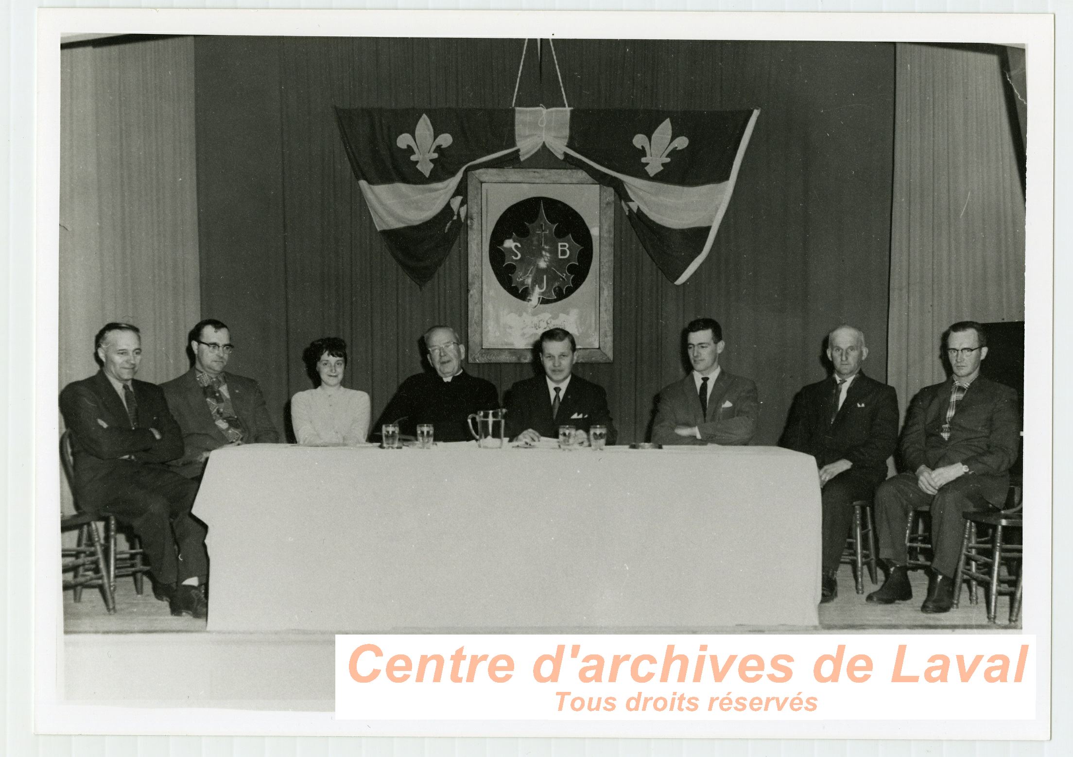 Ernest Vaillancourt sous un drapeau du Qubec accompagn d'un groupe non identifi  Saint-Benot en 1969.