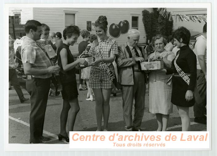 Groupe d'habitants de Saint-Benot et de Saint-Joseph-du-Lac distribuant des pommes en 1969.