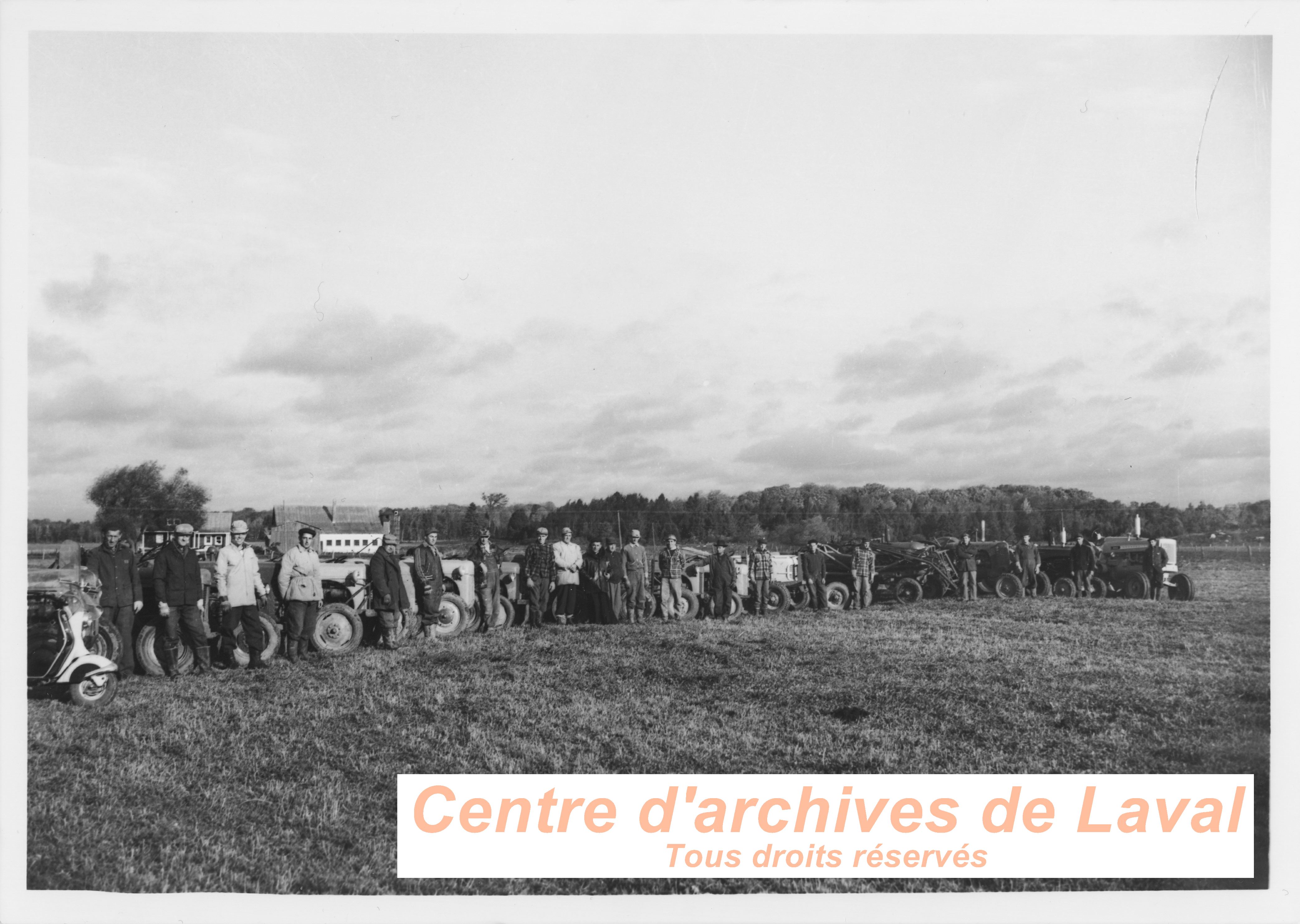 Des agriculteurs posent devant leurs tracteurs dans un champs,  Saint-Benot