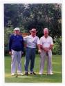Trois personnes non identifiées posent avec des bâtons de golf