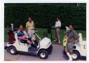 Quatre personnes non identifiées avec deux voiturettes de golf