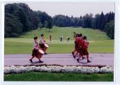 Groupe de musiciens en habits écossais jouant de la cornemuse et du tambour marchent sur une route du terrain de golf