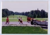 Groupe de musiciens en habits écossais jouant de la cornemuse et du tambour marchent sur une route du terrain de golf