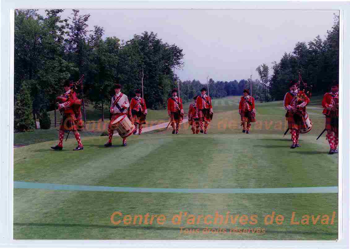 Groupe de musiciens en habits cossais jouant de la cornemuse et du tambour marchent sur le terrain de golf