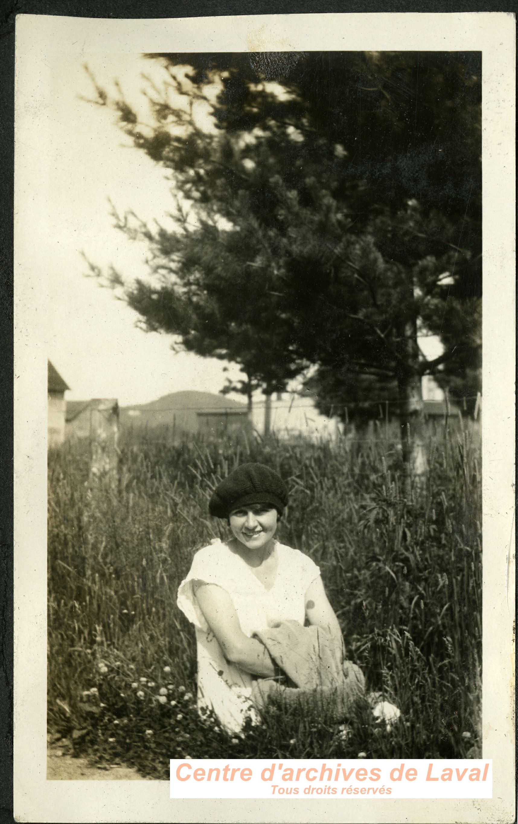 Jeune femme assise dans l'herbe.