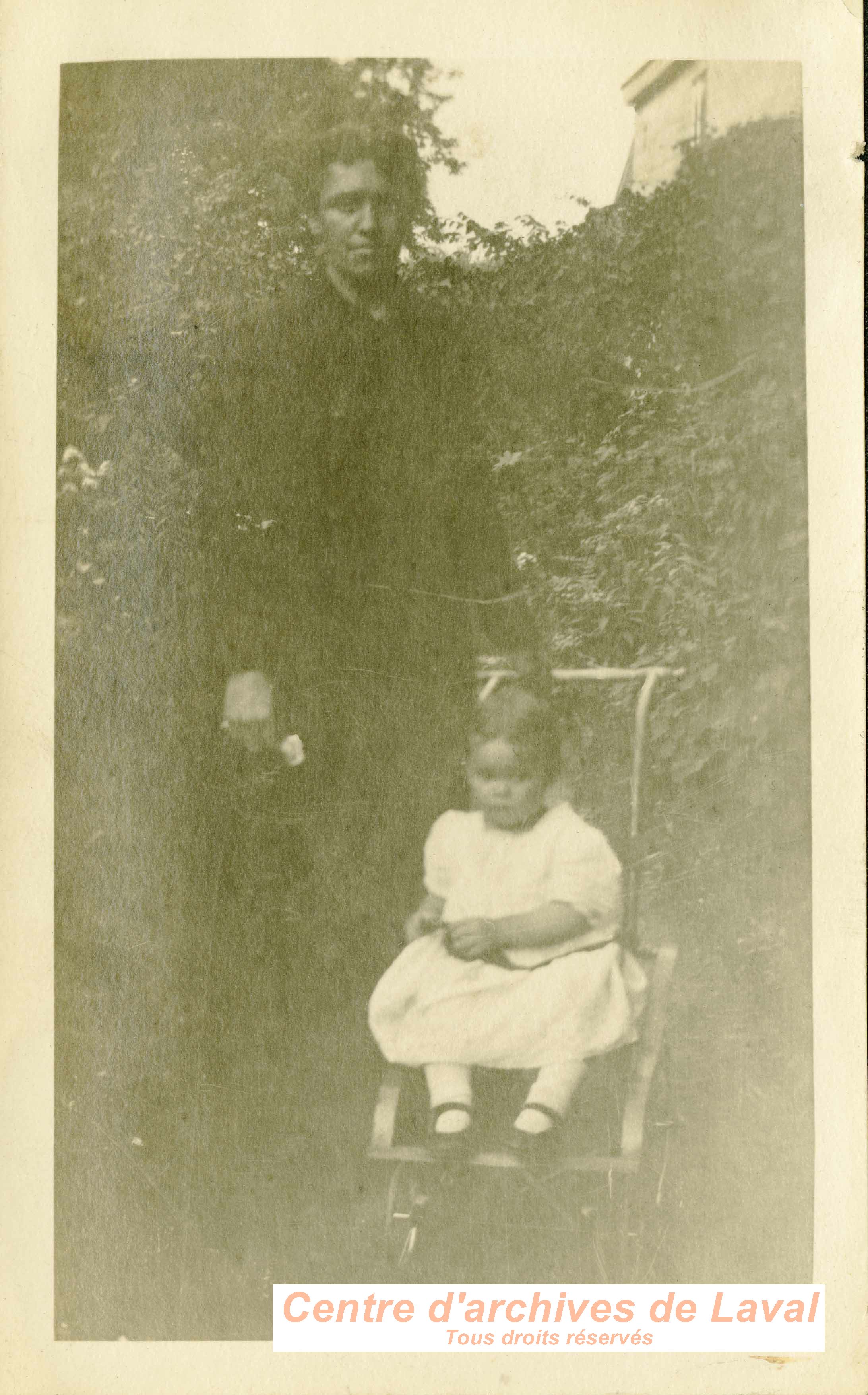 Femme et enfant dans un jardin.