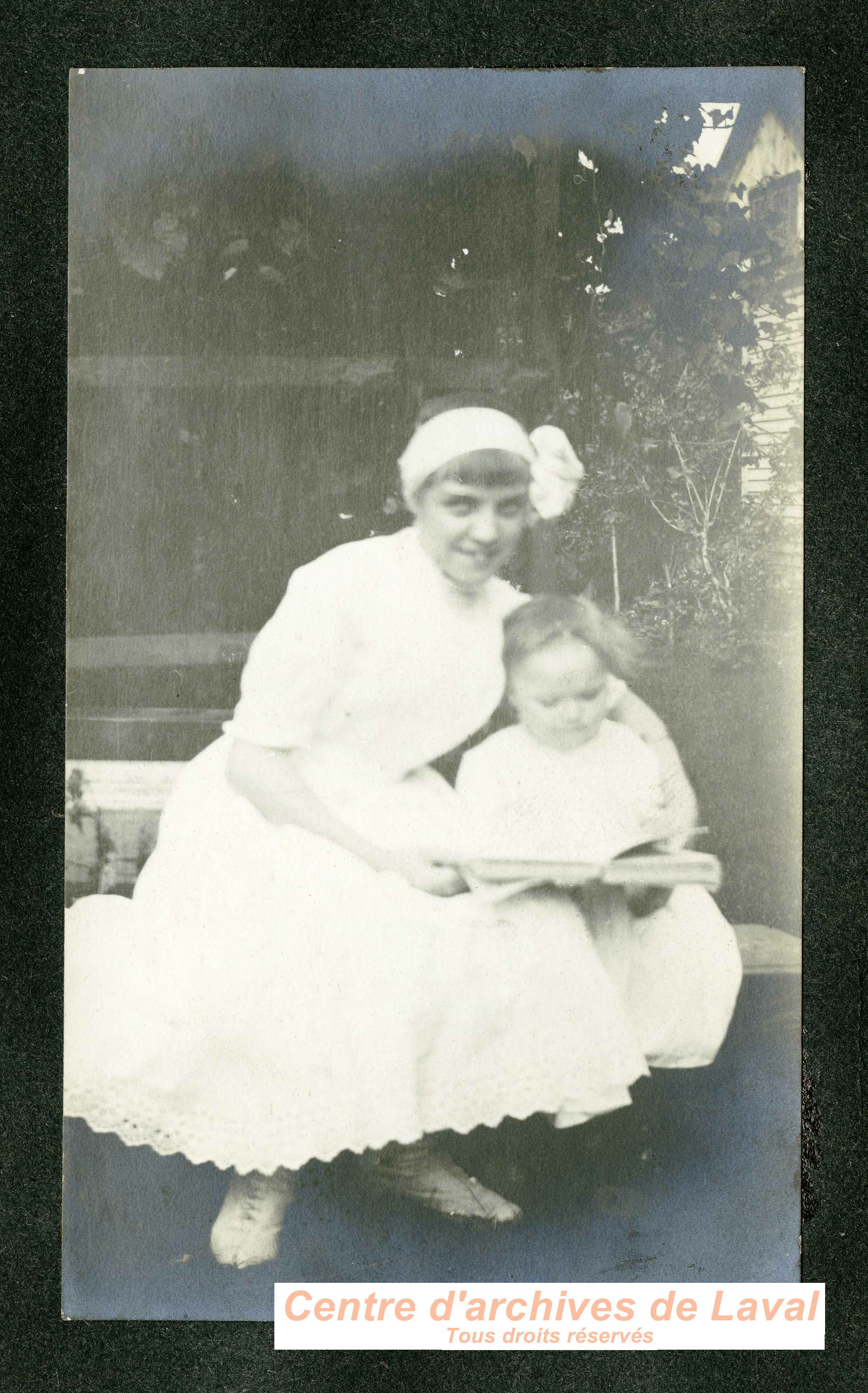 Jeune femme et enfant dans un jardin.