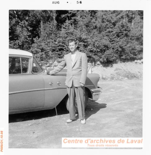 Homme posant devant une voiture